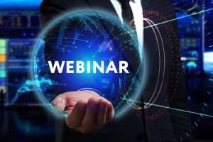 Immagine promozionale di un webinar, con mano che sostiene una sfera digitale e scritta “WEBINAR”.