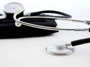 Strumenti medici: stetoscopio e misuratore di pressione su sfondo chiaro.