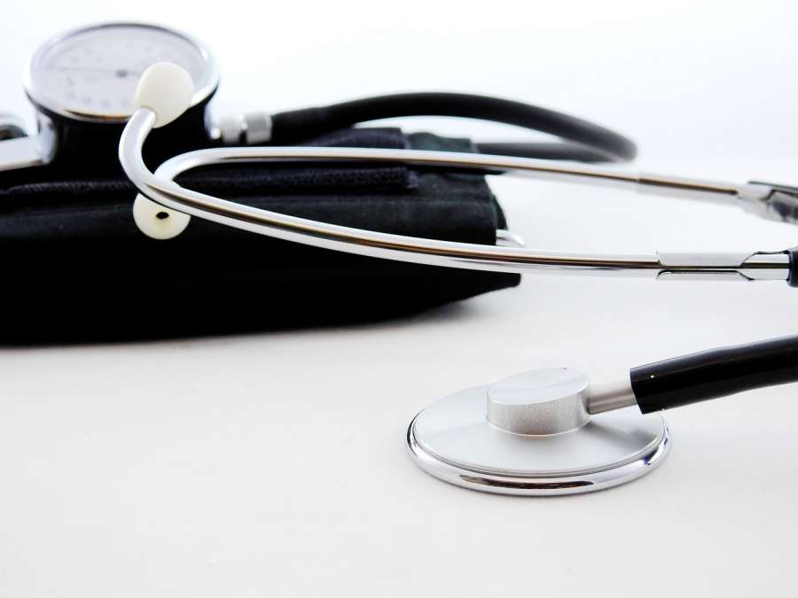 Strumenti medici: stetoscopio e misuratore di pressione su sfondo chiaro.