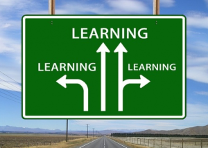 Immagine decorativa di un cartello stradale con la scritta “Learning” e frecce direzionali.