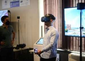 Persona che utilizza un visore di realtà virtuale durante una dimostrazione tecnologica in laboratorio.